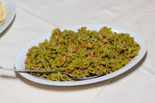 Grön pasta med korv och bacon — Stockfoto