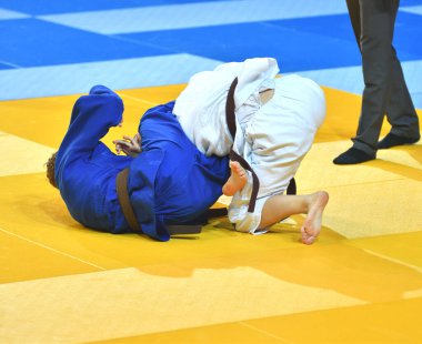 Kimonolu iki kız judoka tatamide yarışıyor. 