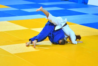 Kimonolu iki kız judoka tatamide yarışıyor. 