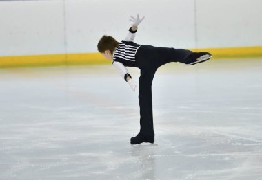 Erkek artistik buz pateni pistinde yapay buz ile yuvarlanıyor.