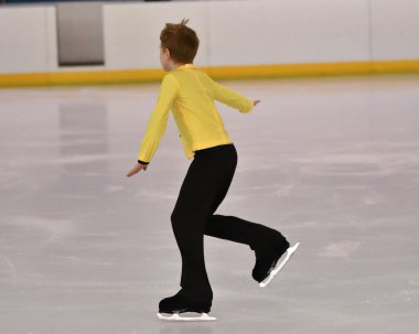 Erkek artistik buz pateni pistinde yapay buz ile yuvarlanıyor.