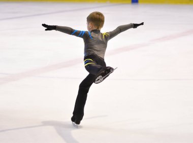 Erkek artistik buz pateni pistinde yapay buz ile yuvarlanıyor.