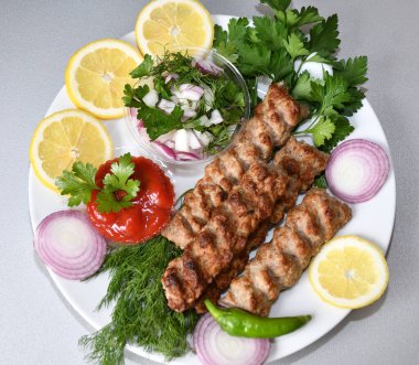 Akdeniz mutfağında taze bitkilerle Lula kebabı.