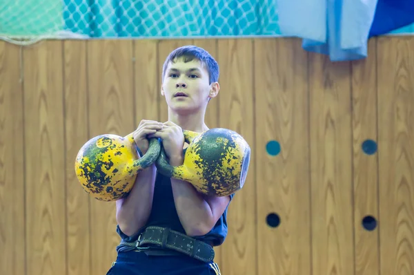 De jongen in de kettlebell sport — Stockfoto