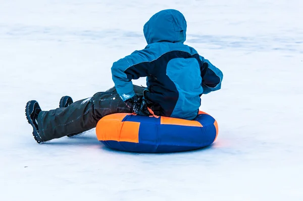 Bambino slittino invernale sul fiume Ural . — Foto Stock