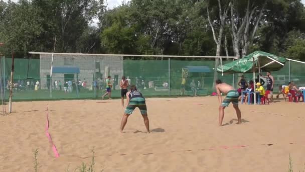 Los hombres juegan voleibol playa — Vídeo de stock