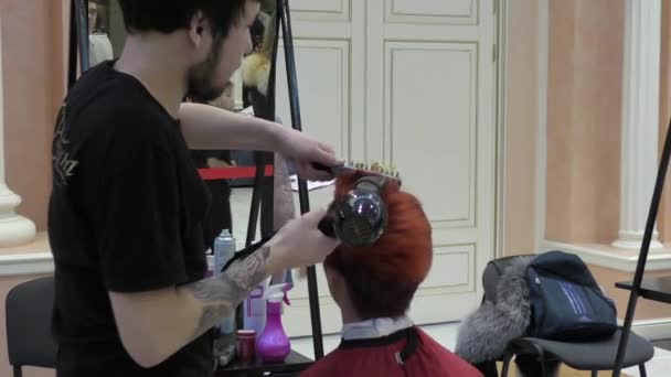 Fryzjer w konkursie sprawia, że mężczyzna fryzurę — Wideo stockowe