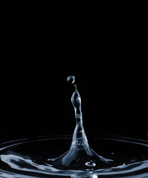 落下する落下から澄んだ水面の液体にスプラッシュとリップル 暗い背景で — ストック写真
