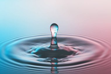 Düşen bir damladan, berrak su yüzeyine sıçrama ve dalgalanma.