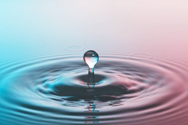 Düşen bir damladan, berrak su yüzeyine sıçrama ve dalgalanma.