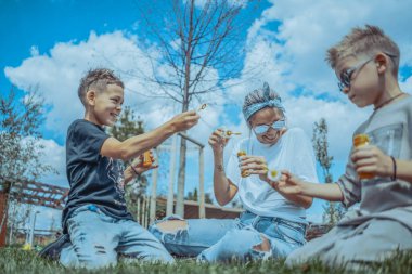 Genç Şık Modern Anne ve İki Oğlu Parkta Köpüren ve Eğlenen Köpükler.