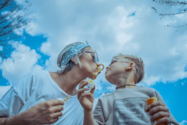 Genç Şık Modern Anne ve Oğulları Parkta Baloncuklar Üflüyor ve KIsses Veriyorlar