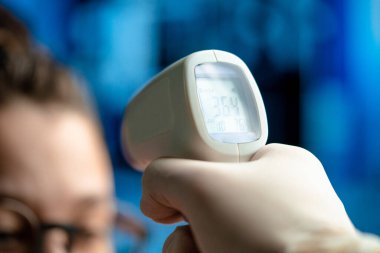 Modern Hastanesi 'nde Doktor Kadın Vücut Sıcaklığını Kontrol Etme Kızılötesi Temas Olmayan Termometre Kullanıyor. Sağlık Araştırmaları Sağlığa Sorumluluk.