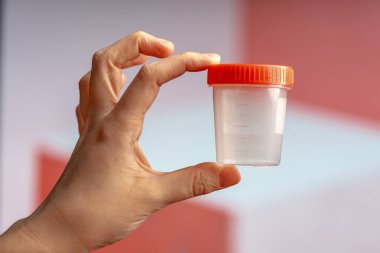 Analiz için boş bir konteynırı tutan kadın. Uyuşturucu testi ya da sağlık kontrolü için konteyner.