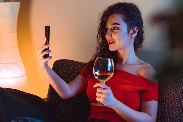 Woman Calling Her Friend By Video Chat And Drinking Wine. Online Date, Online Meeting With Friends. Stay Home. Social Distance, Isolation — стоковое фото