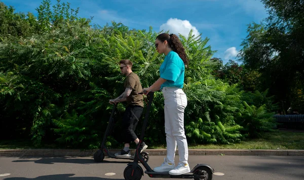 Young Happy Couple Driving Electric Scooters City Park Sunny Summer ストック画像