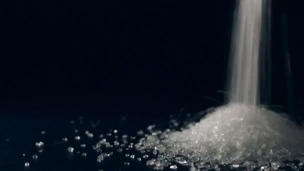 Pouring sugar on black background — Stock Video