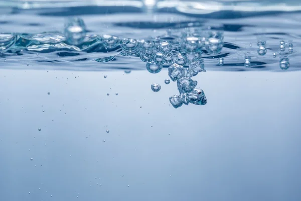 Blaue Blasen nach einem Spritzer im Wasser. Nahaufnahme. unter Wasser Stockfoto