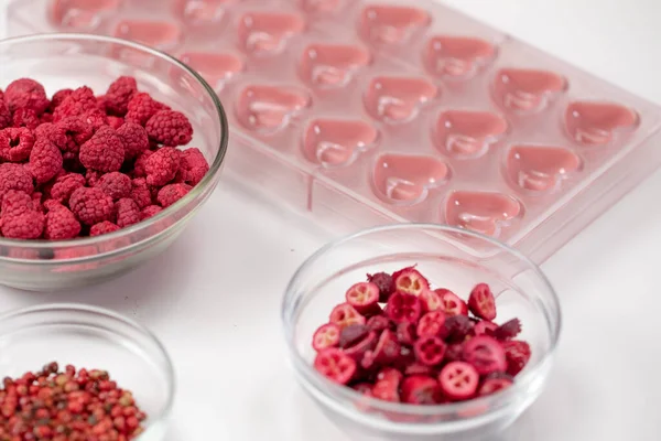 Heart shape confectionery mold with ruby chocolate and dried red berries filling — Stock Photo, Image