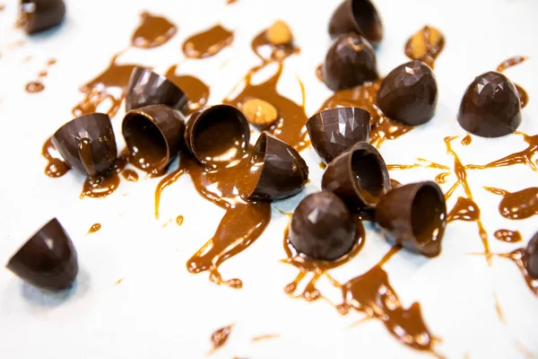 Sweet background, chocolate candies with caramel filling on white worktop