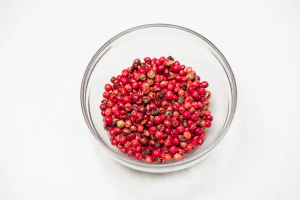 Red peppercorns in glass bowl isolated on white background, organic hot species — Stock Photo, Image