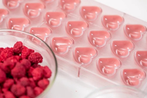 Cukrárna ve tvaru srdce s rozpuštěnou rubínovou čokoládou a sušenými bobulemi — Stock fotografie