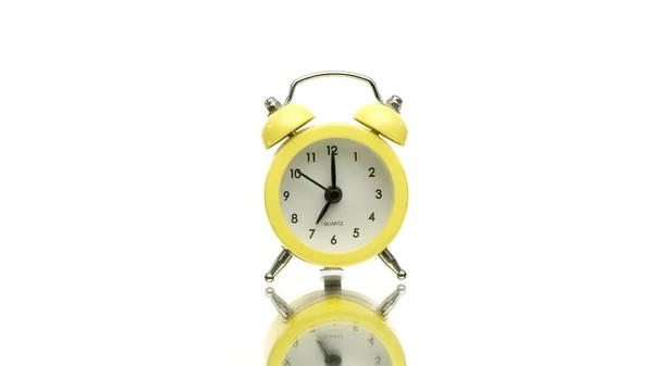 Pequeno relógio de alarme vintage amarelo girando isolado no fundo branco — Fotografia de Stock