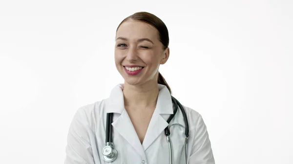 Médica sorri amplamente com um sorriso branco e piscadelas. Isolados — Fotografia de Stock