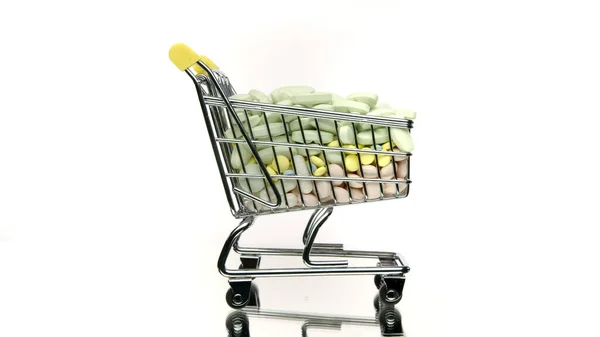 Fechar carrinho de compras com medicamentos girando isolado no fundo branco — Fotografia de Stock