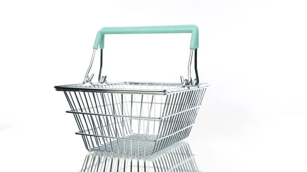 Cesta de compras de metal vazio com alças girando sobre fundo branco isolado — Fotografia de Stock