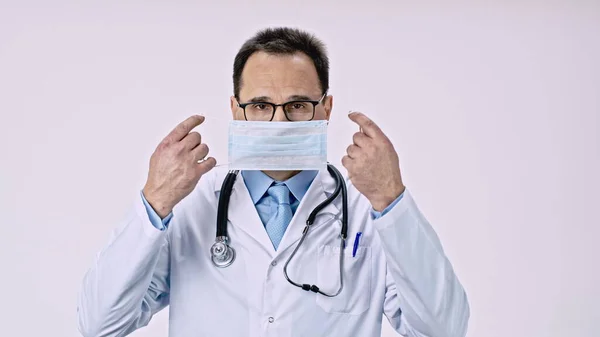 Schöner Arzt setzt Schutzmaske gegen Covid-19-Virus und Bakterien auf — Stockfoto
