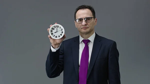 Серьезный мужчина босс указывая на часы в руке со временем 8 утра, управление временем — стоковое фото