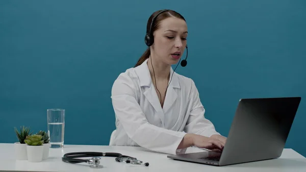 하얀 가운을 입고 있는 섹시 한 여성 의사는 온라인으로 환자들에게 조언을 해 준다. 고립 됨 — 스톡 사진