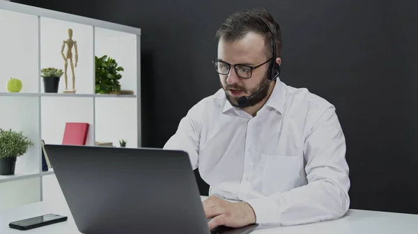 El especialista en soporte técnico asesora al cliente. Hombre caucásico auriculares inalámbricos — Foto de Stock