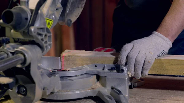 Charpentier utilise scie circulaire Découpe de poutres en bois. Ligne laser rouge à blanc — Photo