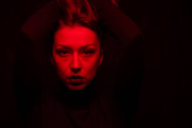 Gösterişsiz bir portre güzel kız uzun saçlarını kaldırdı ve kameraya baktı.