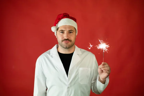 Médico soñoliento con sombrero de Santa Claus Celebrando la Navidad o Año Nuevo de guardia — Foto de Stock