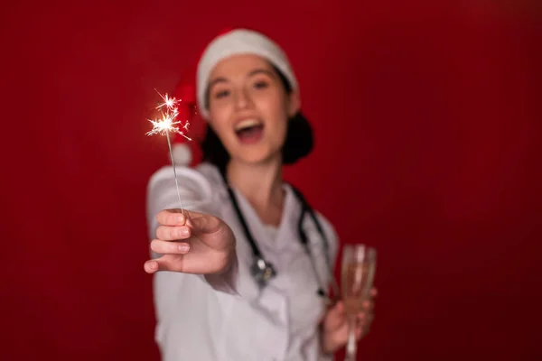 Brennende Wunderkerzen in der Hand einer sexy Ärztin, die Weihnachten, Neujahr selebriert — Stockfoto