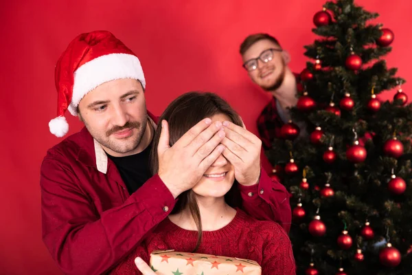 Roliga julöverraskningar koncept. sällskap av vänner vid julgranen — Stockfoto