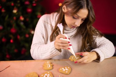 Gelenekçi kavram. Tatlı esmer, genç bir kadın Noel çöreğini donduruyor.