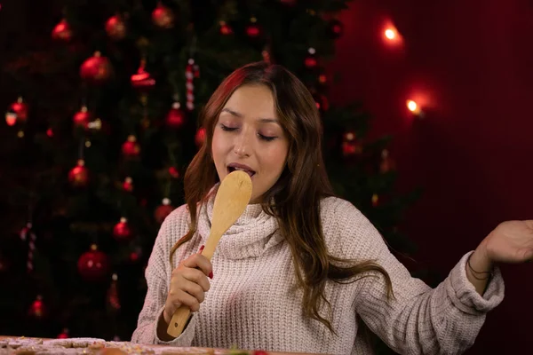 Joven bonita mujer divertirse en la cocina de Navidad, canta canciones de Navidad con espátula — Foto de Stock