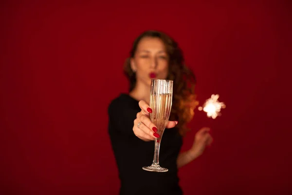 Fête. Femme joyeuse clin d'oeil et souffle un baiser. Focus sur le champagne — Photo