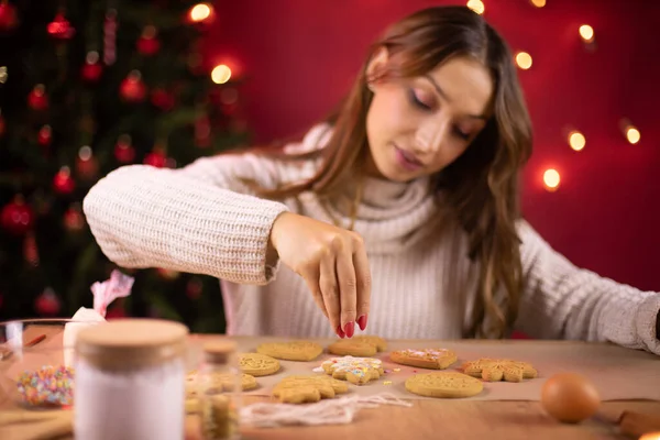 Horneado de Navidad. Mujer bonita decorar galletas de jengibre con chispas de azúcar — Foto de Stock