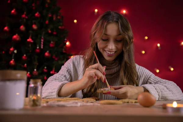 Chica morena sonriente decorando galletas de Navidad. hecho a mano Mindful Gifting — Foto de Stock