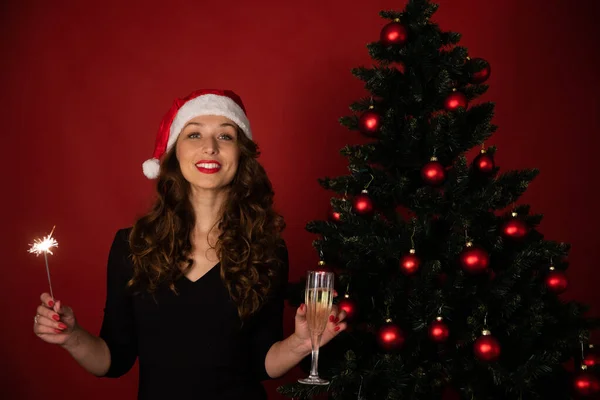 Hermosa chica morena en Santa Claus sombrero toma saludos de Navidad en línea —  Fotos de Stock