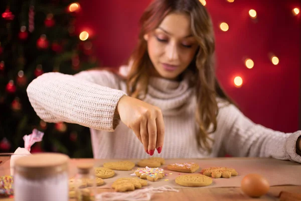 Linda chica morena decorando galletas de Navidad en la decoración de Navidad — Foto de Stock