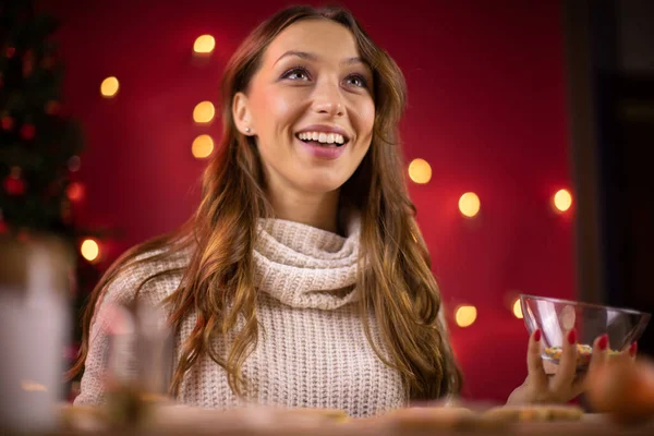 Horneado de Navidad. bonita mujer joven sonriendo mirando hacia otro lado en la decoración de Navidad — Foto de Stock