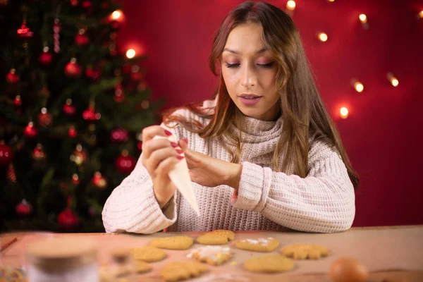 Horneado de Navidad. Mujer bonita decoración de galletas de jengibre de Navidad con hielo — Foto de Stock