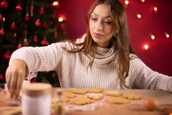 Bastante morena de pelo largo chica decorando galletas de Navidad — Foto de Stock