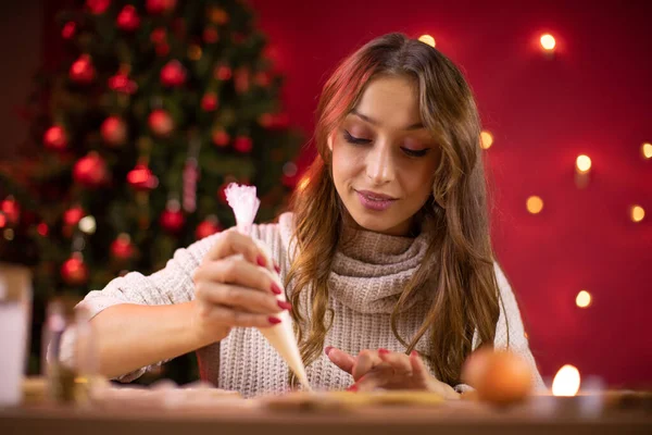 Hermosa mujer hace galletas de Navidad. Acogedora noche de invierno en casa — Foto de Stock